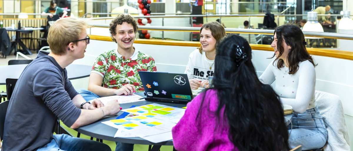 vijf hbo-ict studenten werken in de vide aan een groepsopdracht
