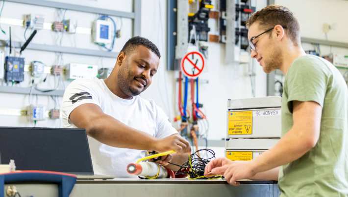 Twee deeltijdstudenten bezig met elektriciteitskabels.