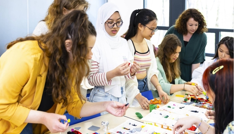 Studenten en Ingeborg samen aan het werk rond een tafel