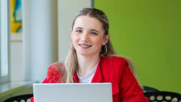 Student hbo HRM aan het werk op de HAN in Nijmegen en kijkt in de camera