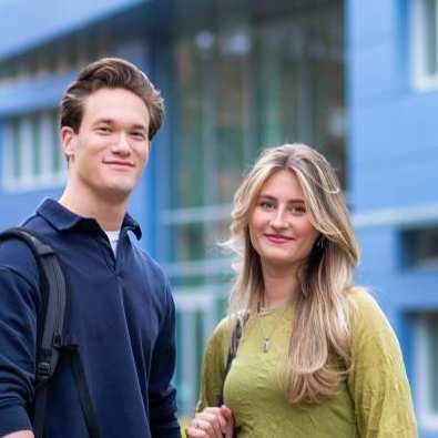 Twee studenten van Learning and Development in Organisations voltijd kijkend in de camera voor Laan van Scheut 10 in Nijmegen.