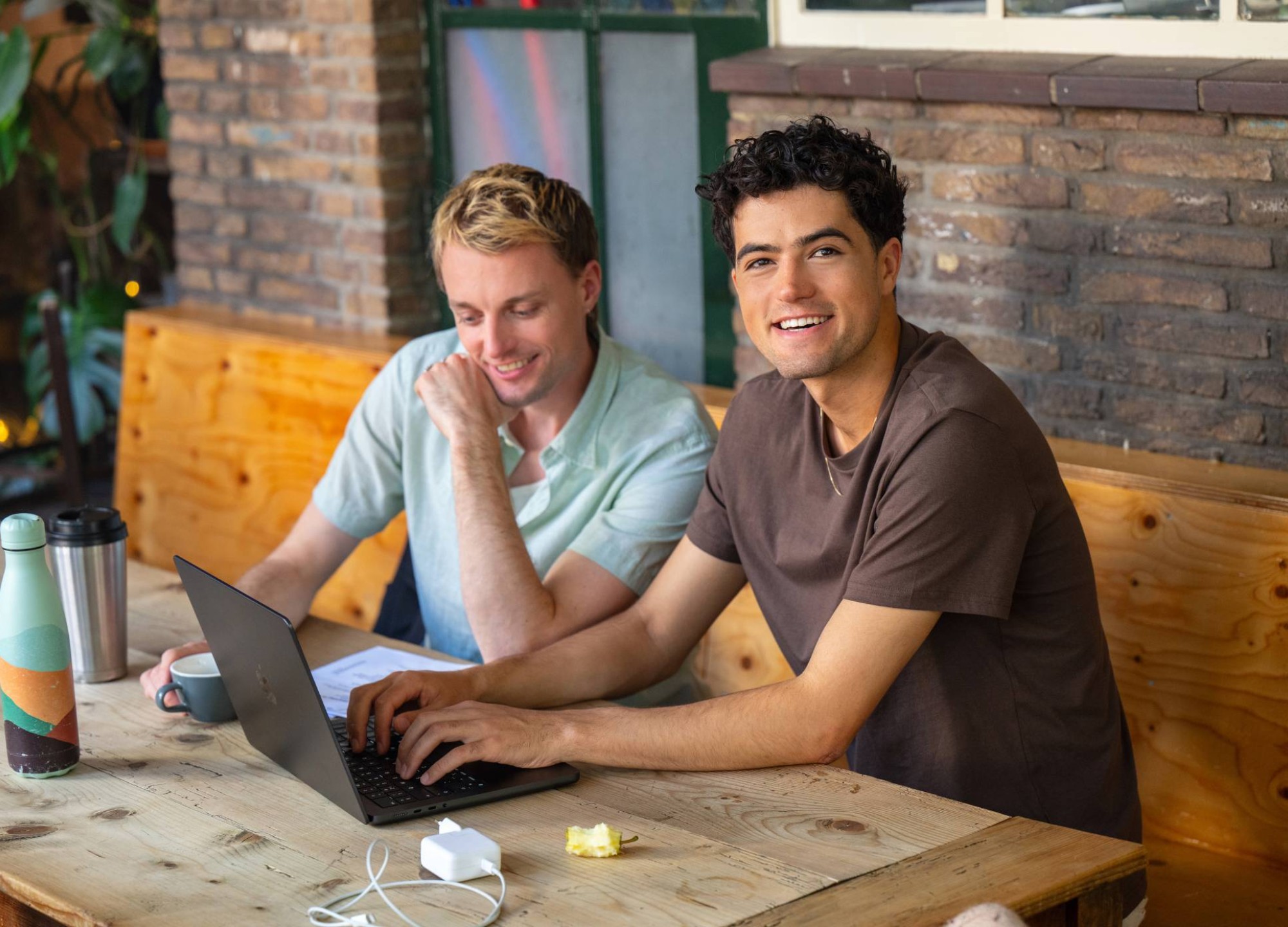 2 hbo masterstudenten werken aan hun laptop.