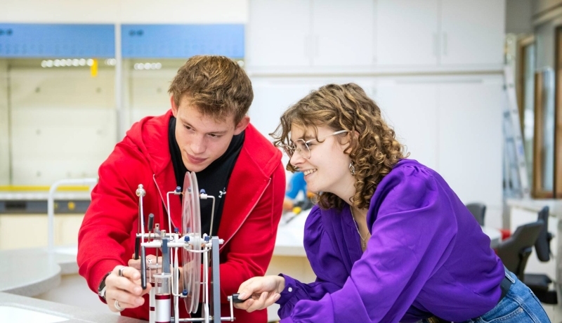 Twee studenten Leraar Natuurkunde kijken aandachtig naar hun experiment.