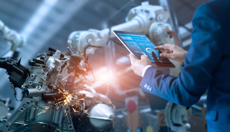 Engineer staat op slimme productievloer met robotarmen