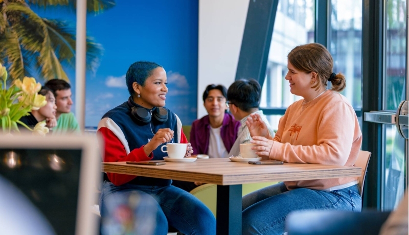 Students Noa, Chadionne, Tam, Diego, Nyugen and Andrei relaxing and drinking coffee in the Hangar on the Arnhem campus of HAN University of Applied Sciences.
