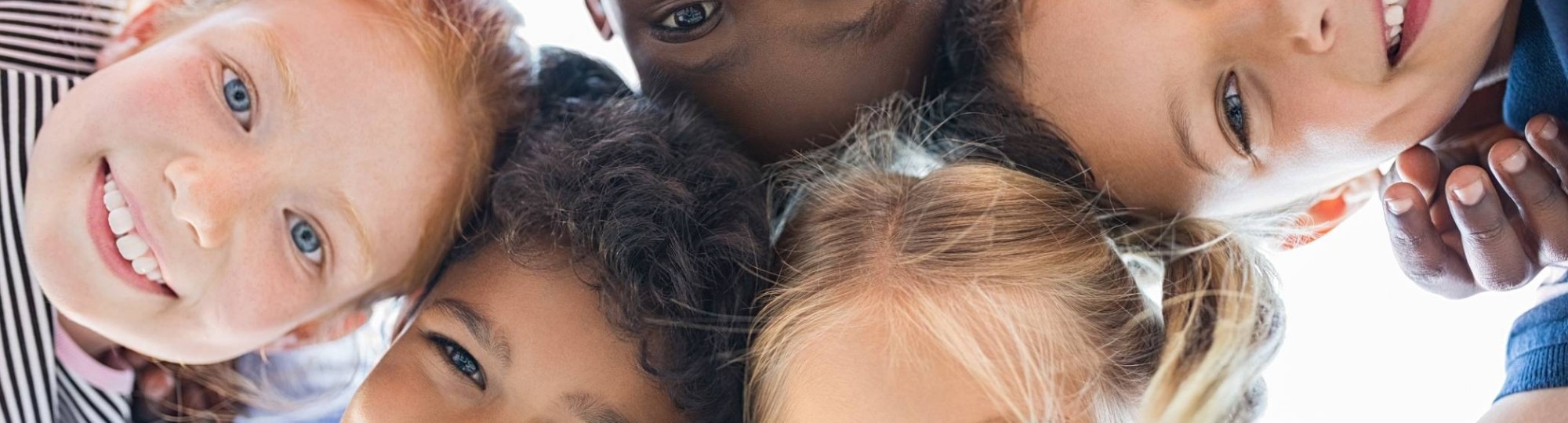 Vijf blije kinderen kijken naar beneden