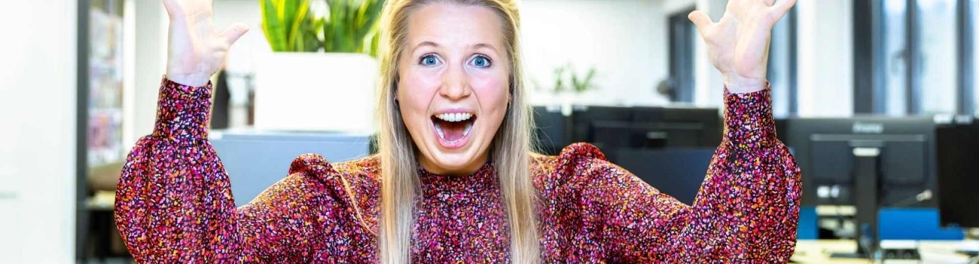 Juichende dame blond achter computer in kantoor