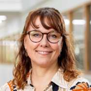 Debra Trampe, portretfoto, gevlekte blouse, brildragend