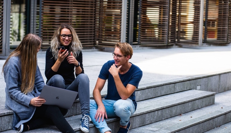 Jonge mensen zitten buiten op trap