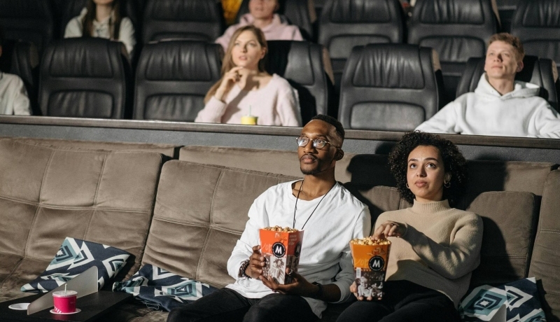 Alumni van Social Work kijken naar een documentaire terwijl ze popcorn eten.