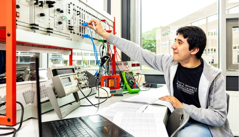 Een student elektrotechniek doet een netwerkpracticum.