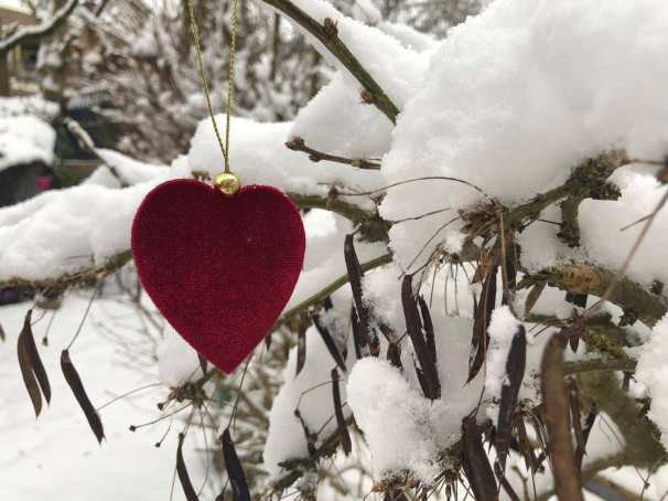 Een foto van een rood hart in de sneeuw