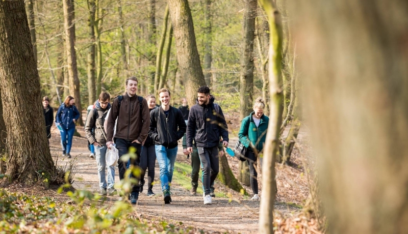 Groep biologie studenten lachend in het bos