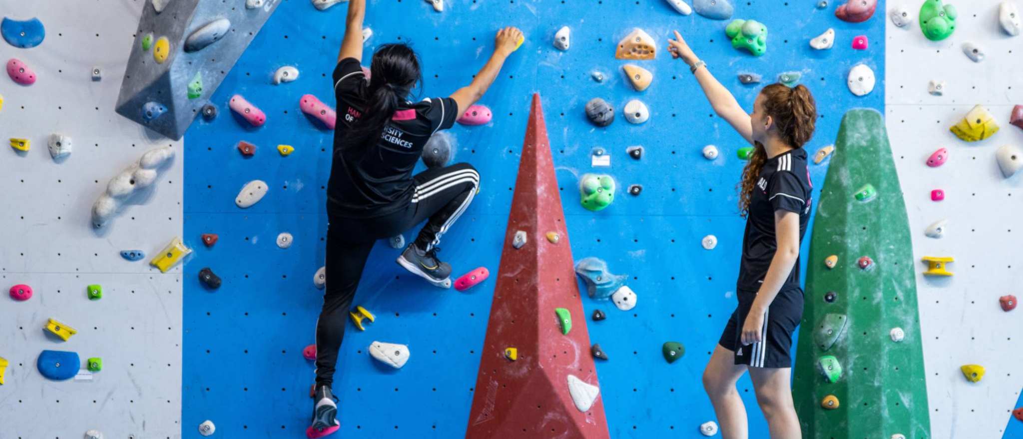 alo liggende foto esteban op klimwand van achterzijde selena geeft uitleg 2022