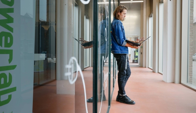 Leunende Joris met een laptop in z'n handen. SEECE, hybride leeromgeving, IPKW, MIC, Powerlab, Engineering, Elektrotechniek, Werktuigbouwkunde, Industrieel Product Ontwerpen