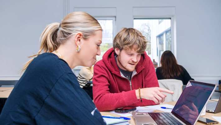 Leraar FastSwitch onderwijs kijkt mee met studenten.