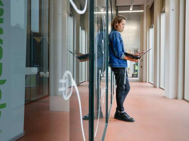 Leunende Joris met een laptop in z'n handen. SEECE, hybride leeromgeving, IPKW, MIC, Powerlab, Engineering, Elektrotechniek, Werktuigbouwkunde, Industrieel Product Ontwerpen