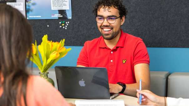Mannelijke student Social Work lacht tijdens een college op de HAN want hij is 21+ en gestart met de studie Social Work.
