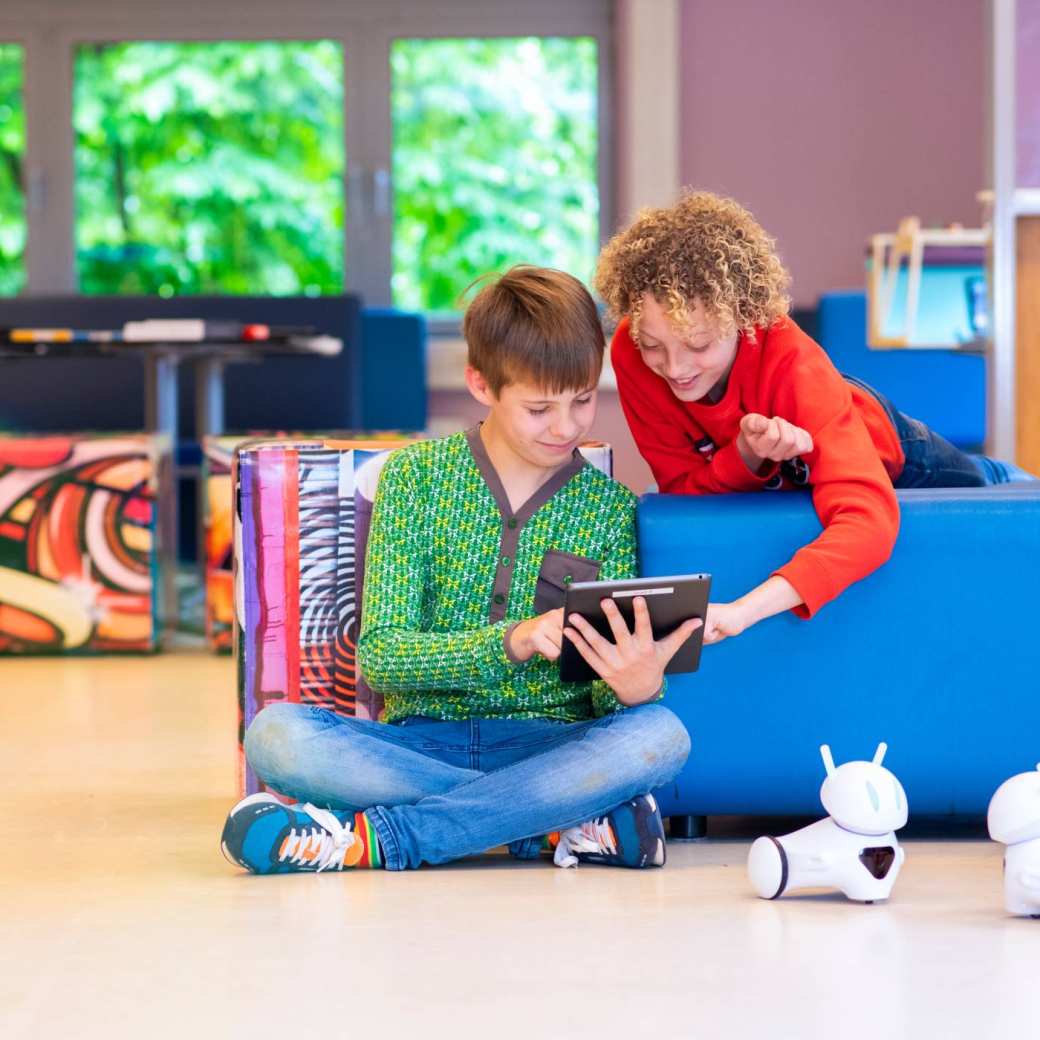 Twee jongens kijken samen naar de  iPad. 