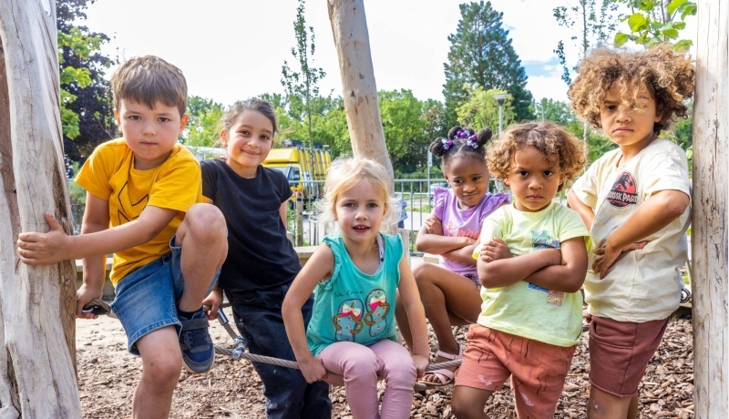 Zes kinderen poseren tijdens het buitenspelen op het klimrek. Foto van de opleiding leraar basisonderwijs 