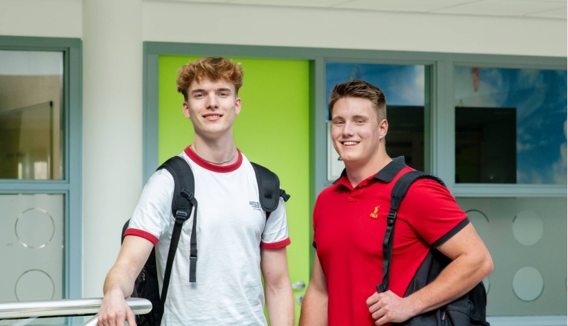 Studenten van de associate degree Bedrijfskunde kijken lachend in de camera