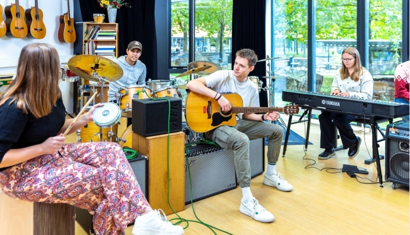 Een foto van studenten HAN Social Work die samen muziek maken tijdens het creatieve vak muziek.