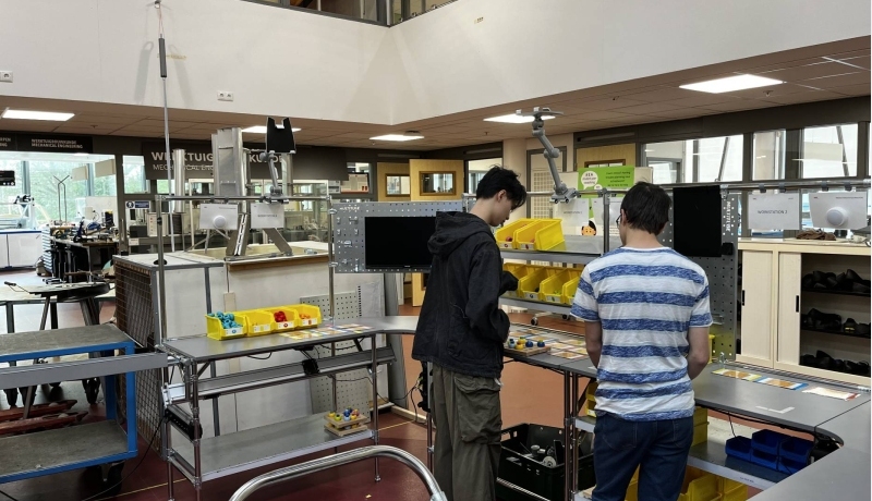 Studenten volgen een workshop aan de u-vormige assemblagecel
