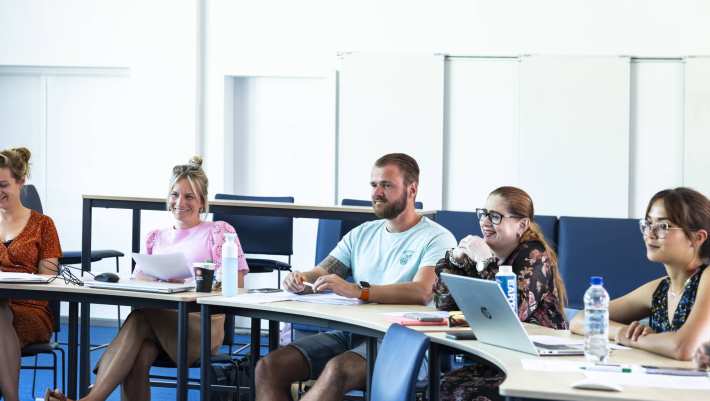 Studenten van de Master Social Work lachen tijdens uitleg