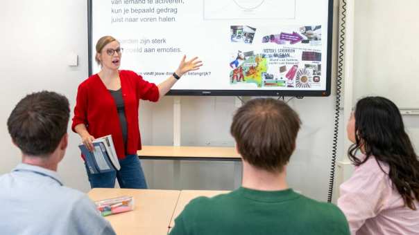 Docent van Toegepaste Psychologie geeft uitleg aan een klein groepje studenten