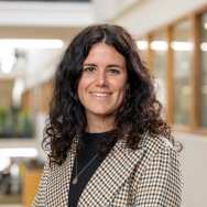 Portretfoto Tanja van Grinsven, donker t-shirt met geruit jasje eroverheen