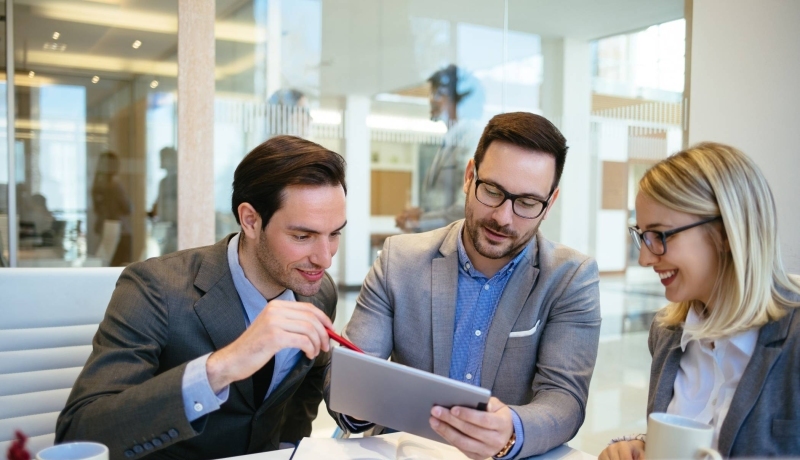 Foto van drie mensen in overleg met tablet in de hand voor projectpagina Associate lectoraat Sustainable Finance & Tax