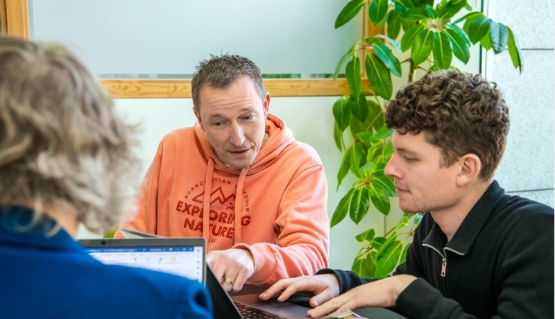 3 masterstudenten zitten bij elkaar en kijken bij één op de laptop
