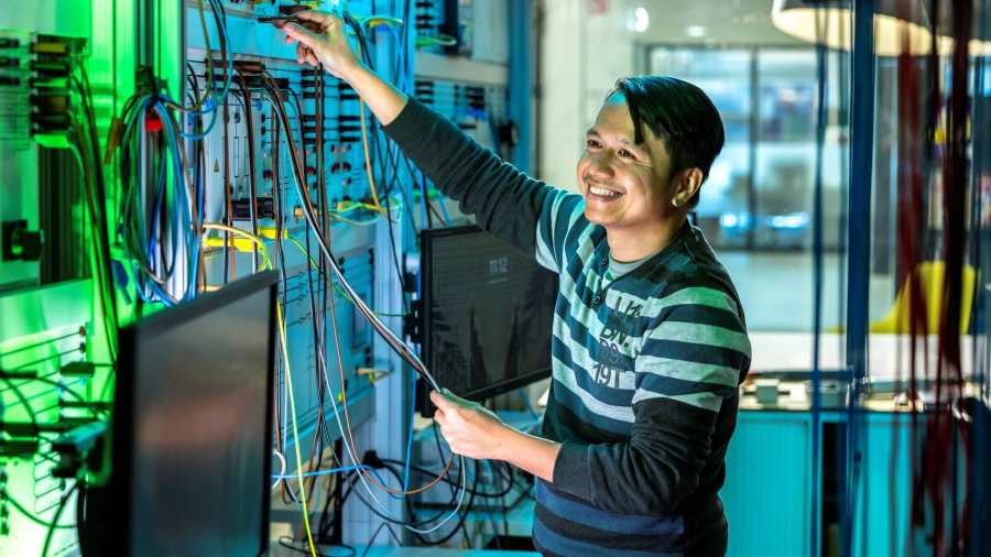 Lachende man test de installatie van de smart grid in de WATTS simulatieruimte.
