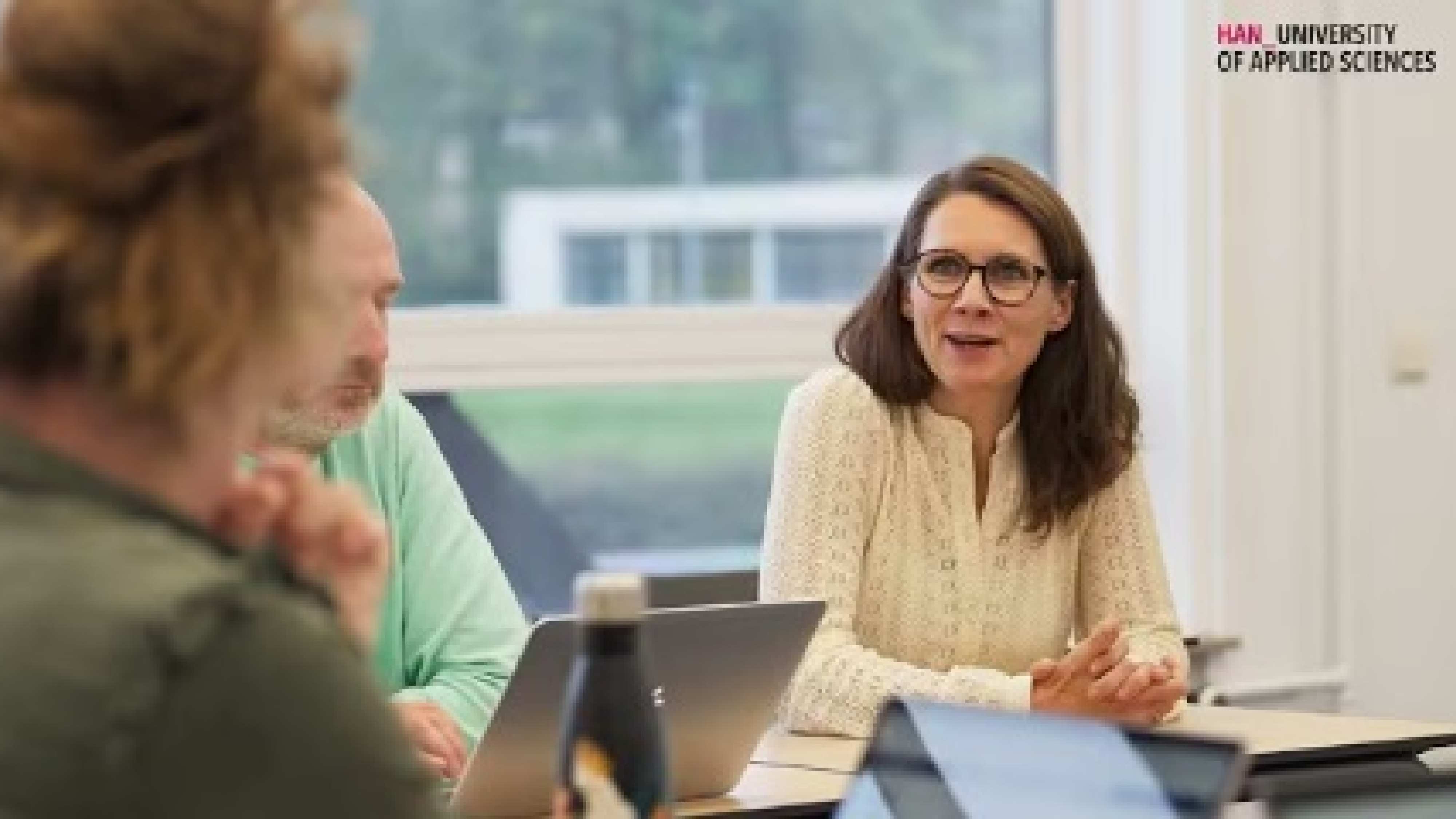 Student kijkt lachend medestudenten aan