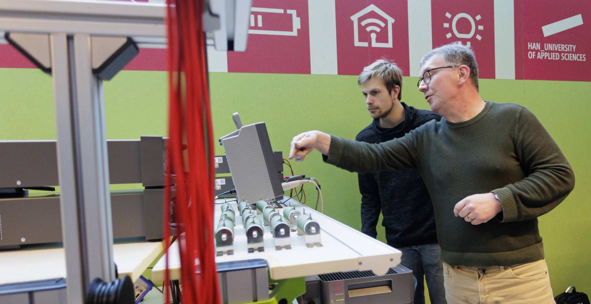Jan Geurts van Kessel (HAN) en Wouter Rekswinkel (ElaadNL) samen aan het werk in het Power Lab