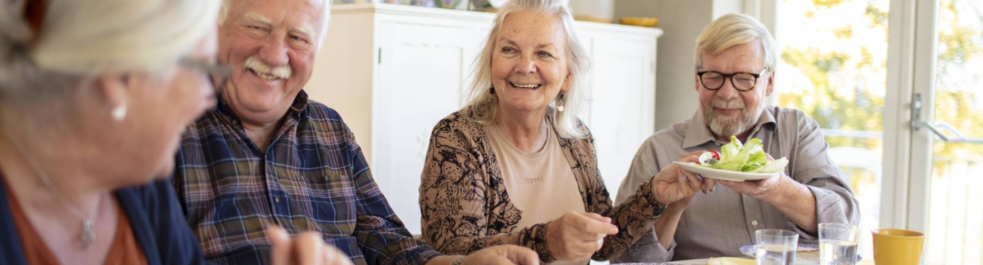 Groep ouderen aan tafel tijdens het ontbijt in een verpleeghuis