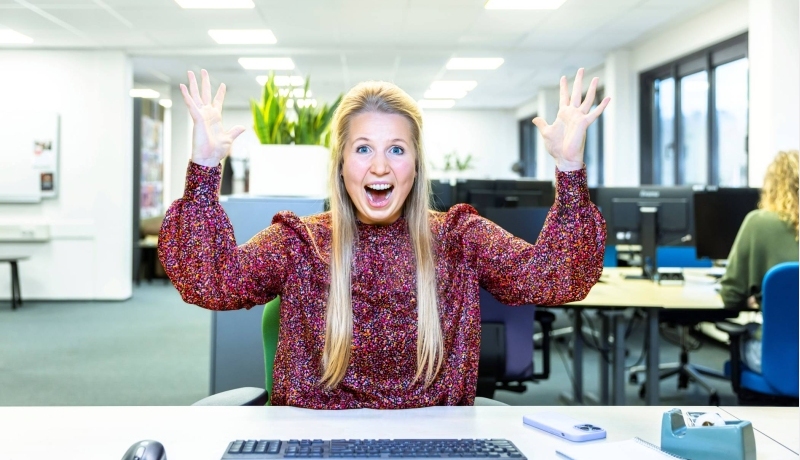 Juichende dame blond achter computer in kantoor