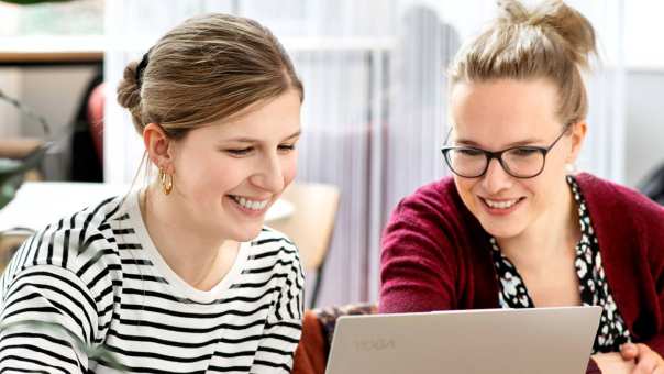 2 studenten aan het werk met de short video op een laptop.