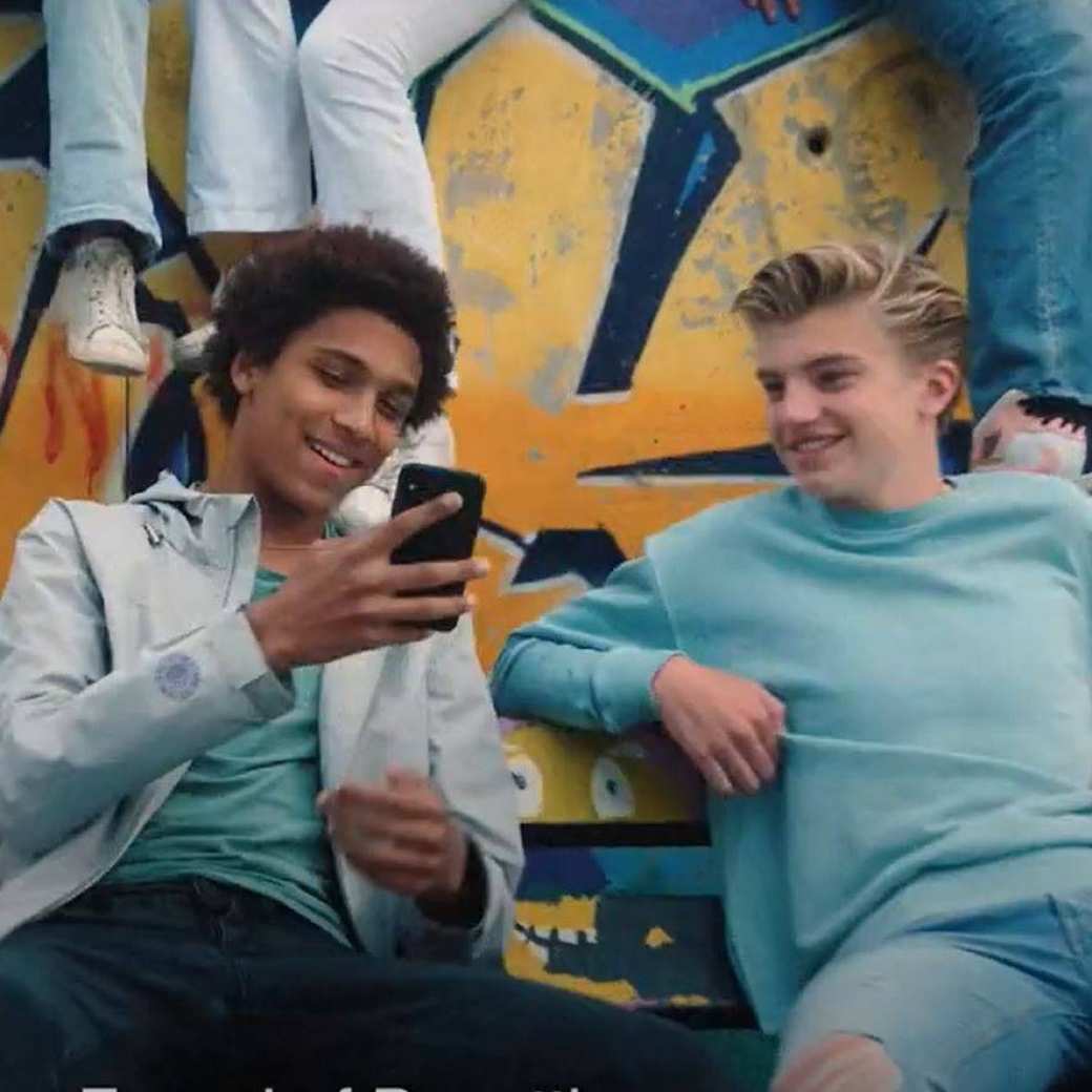 twee jongens kijken op hun telefoon