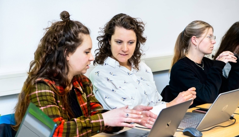 Studenten overleggen aan tafel.