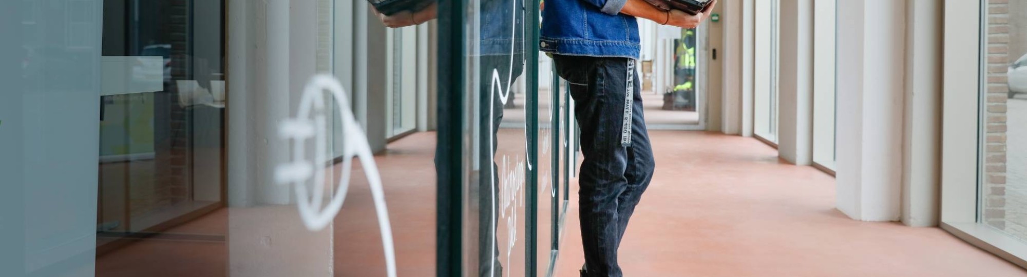 Leunende Joris met een laptop in z'n handen. SEECE, hybride leeromgeving, IPKW, MIC, Powerlab, Engineering, Elektrotechniek, Werktuigbouwkunde, Industrieel Product Ontwerpen