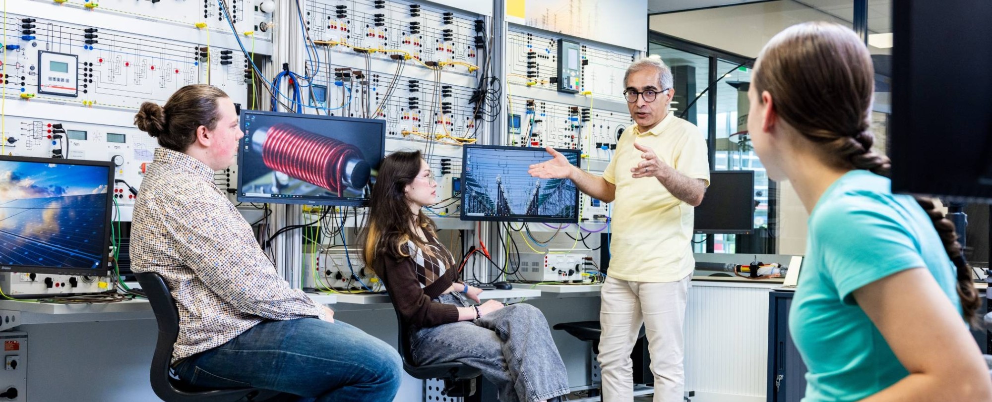 Studenten en docent elektrotechniek tijdens een les in het hoogspanningslab.