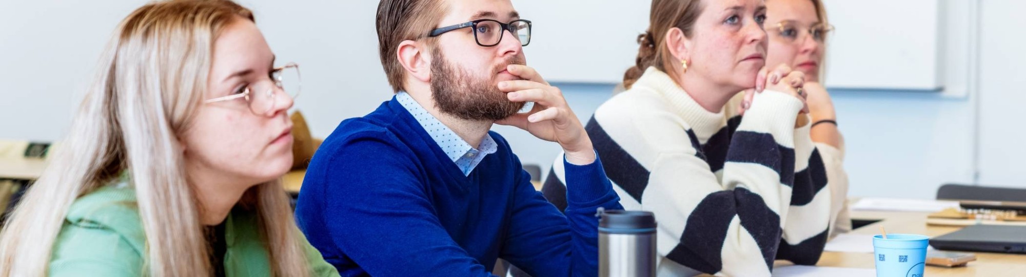 Man en drie vrouwen luisteren naar presentatie. Op de Groenewoudseweg. De opleiding maag-, lever-, darmverpleegkundige.