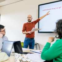 Leraar Nederlands staat voor de klas voor een whiteboard.