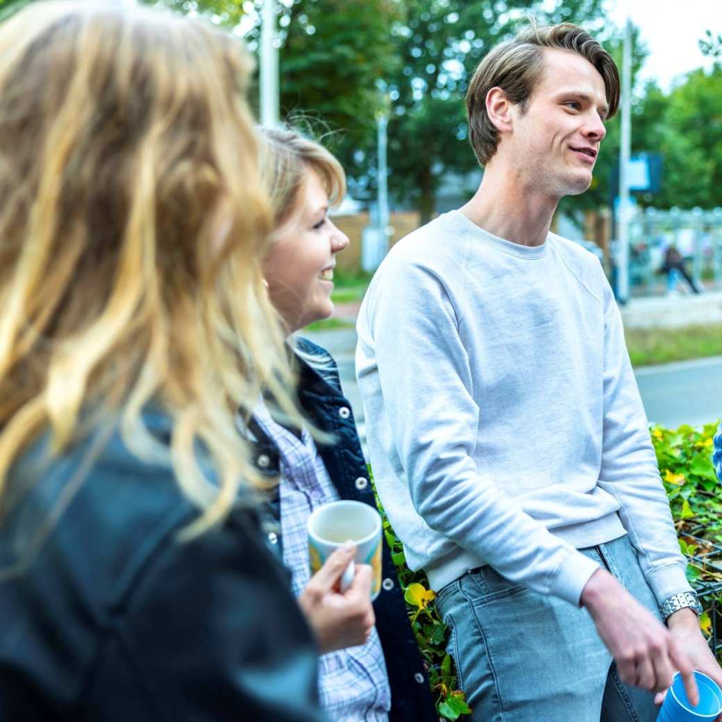 Een groep studenten HAN Social Work zijn samen buiten in gesprek.