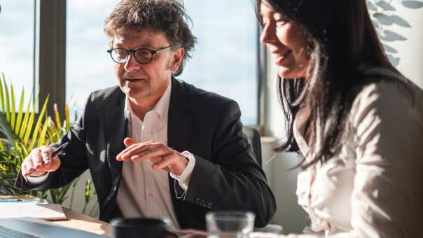 Financieel adviseur geeft integraal advies aan cliënt op een kantoor