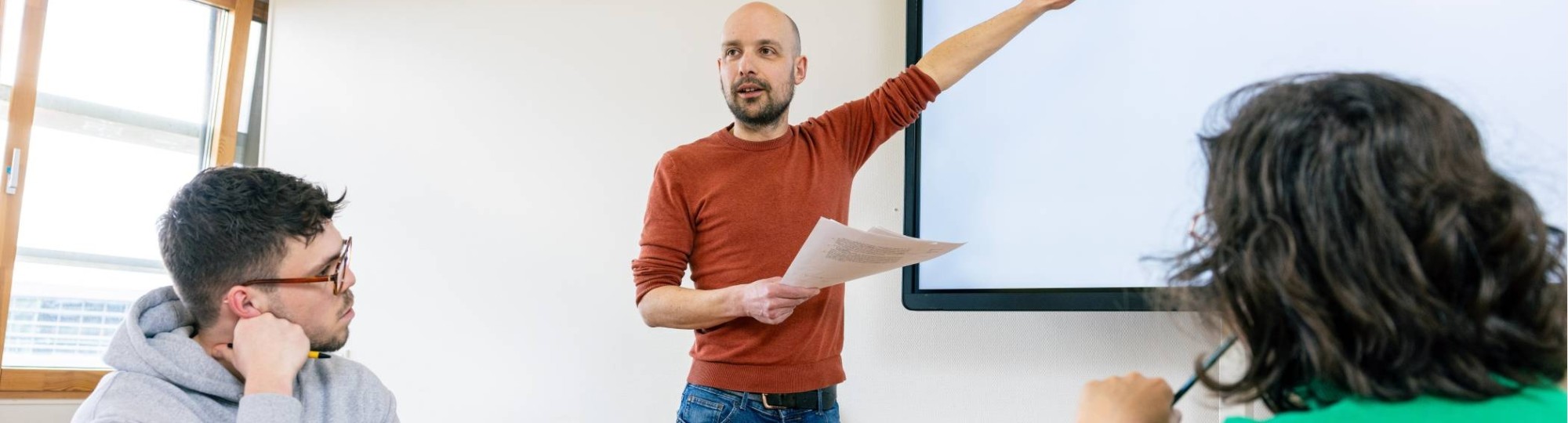 De leraar geeft les aan studenten. 