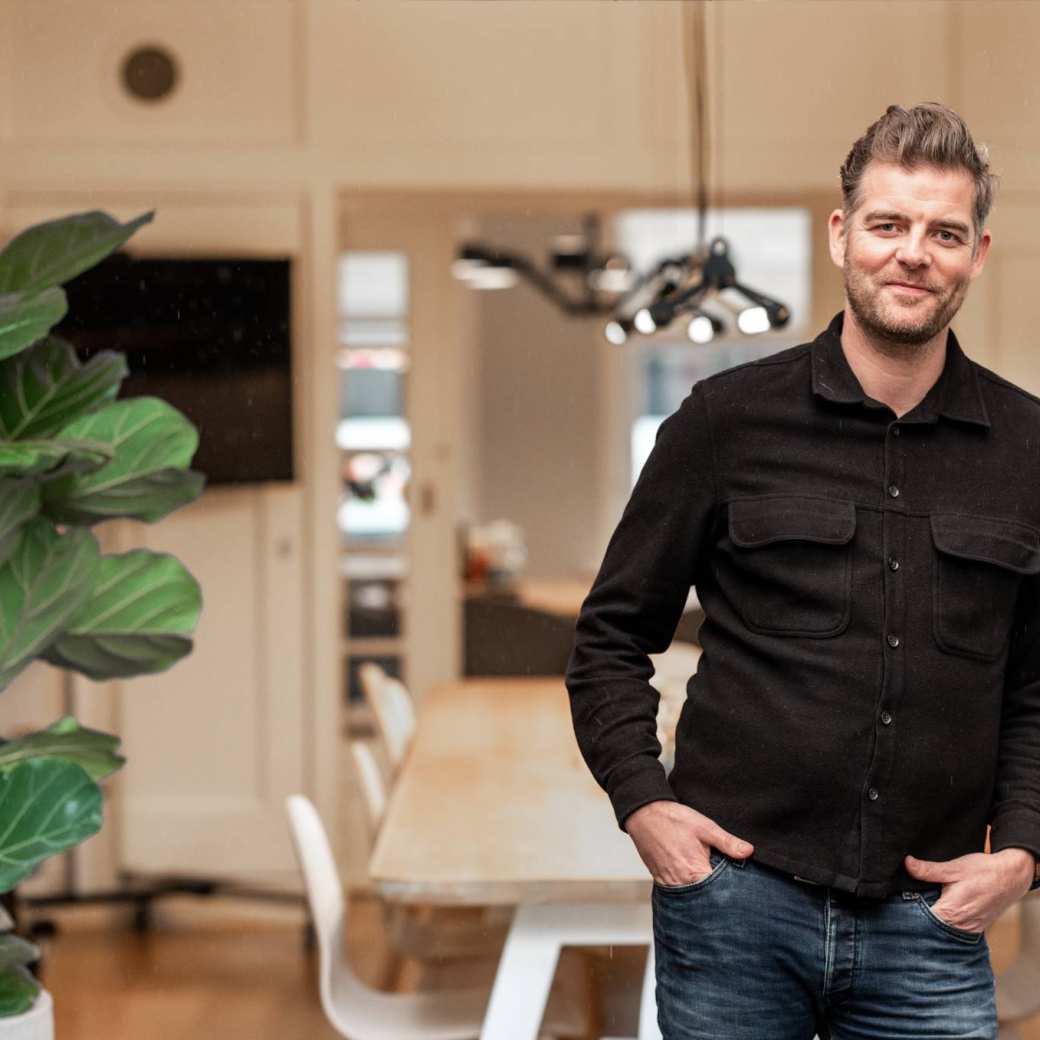 Peter Hoefnagels leunt tegen de deurstijl