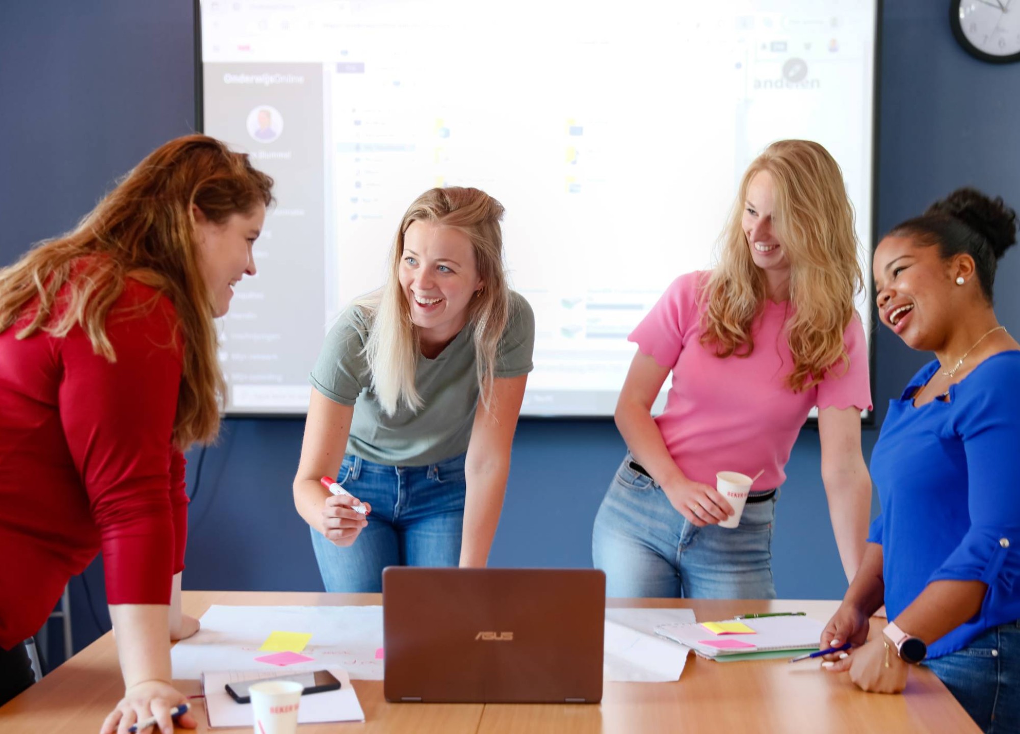 Studenten aan tafel en voeren projectoverleg met flipover vel