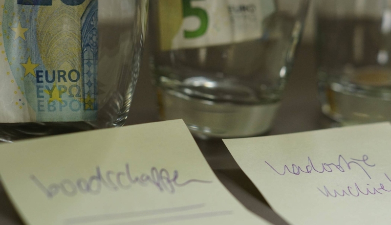 glazen met geld, en een briefje ervoor met 'boodschappen'